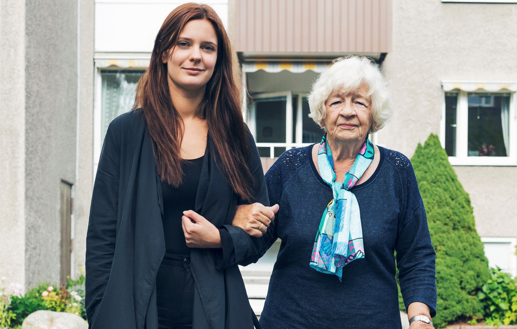 Äldre kvinna utomhus med ung ledsagare