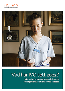 Kvinna i arbetskläder tittar på en medicindosett