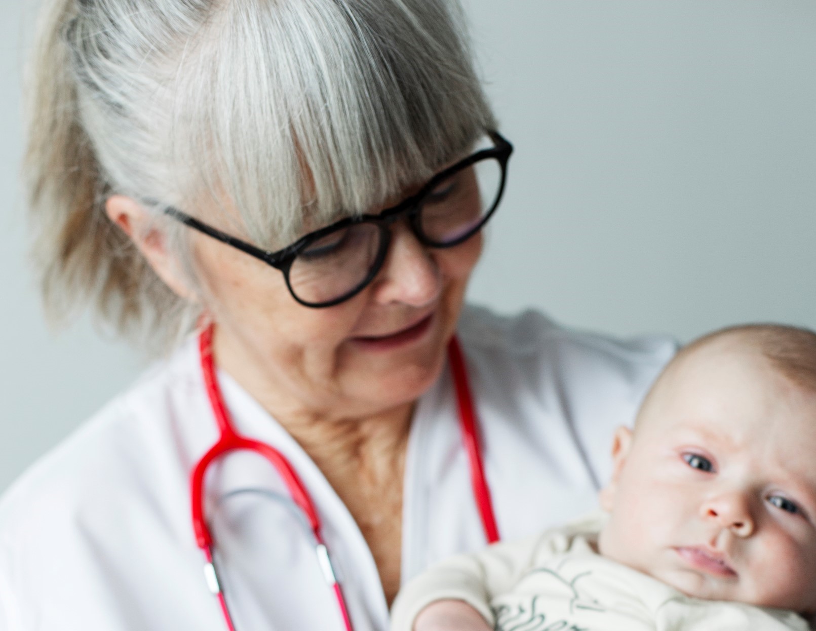 Läkare håller en baby i famnen Läkare håller en baby i famnen