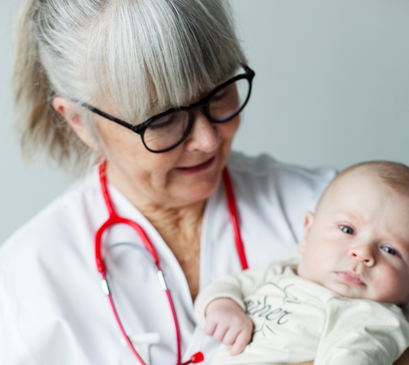 Läkare håller baby i famnen Läkare håller baby i famnen